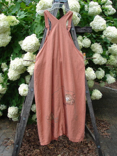 Bluefishfinder.com 1998 Botanicals Planters Overall Jumper Leaf Mimosa Size 0, a dusty rose sleeveless overall jumper with a V-neck and loose, ankle-grazing silhouette. It hangs on a dark wooden ladder amid dense white hydrangeas and green leaves, with a softly faded botanical print near the hem.