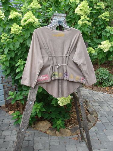 1993 Tie Back Jacket Car Bay Leaf OSFA displayed on a wooden ladder, showcasing its unique drop shoulders and antique car theme paint. The jacket's original buttons and double drawcord back are visible.
