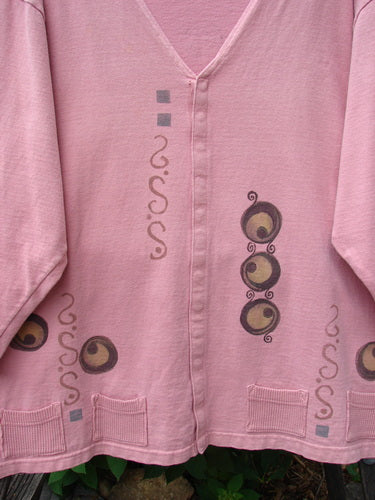 1996 Celtic Jacket of Picts Caille OSFA featuring brown circular and swirl designs on a pink heavy-weight jersey with a deep V neckline, front snaps, and contrasting fabric hem pockets.