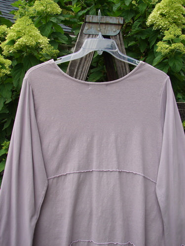Barclay Cotton Lycra Vertical Gather Drop Pocket Dress Unpainted Lavender Size 2 displayed on a hanger, featuring a deep V neckline, oversized front gathered pockets, and sweet lettuce edges.