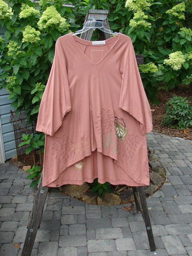 1998 Botanicals Bell Flower Top Magnolia Size 2 displayed on a wooden swing, showcasing its A-line shape, upward scooped front hem, rounded neckline, and blue fish signature patch at the back.