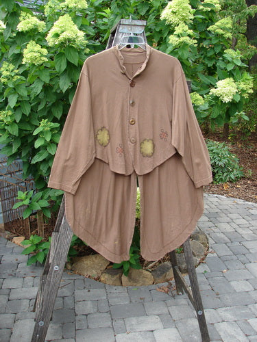 1997 Tails Jacket Day Cloud Mandorla OSFA displayed on a rack, showcasing its mandarin-style mock neckline, oversized shiny brown buttons, front dippy tails, and long tuxedo back tails with lacing.