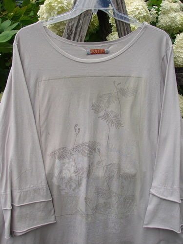 Bluefishfinder.com Barclay Petal Sleeve A-line Tunic in Falling Fern Birch Bark, a soft birch bark top with petal sleeves, a wide scoop neckline, and a faded fern-and-floral print centered on the front. The loose drape and layered sleeve cuffs give it a light, airy silhouette.
