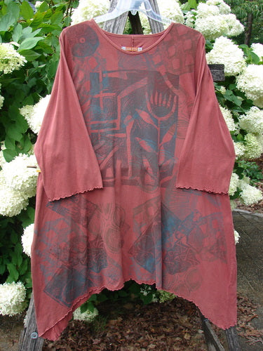 Bluefishfinder.com Barclay Three Quarter Sleeve Color Wheel Tunic Tulip Dream Clay Size 1 in muted clay red, with three-quarter sleeves, a rounded neckline, and an asymmetrical hem. The soft, semi-sheer fabric shows layered tonal prints across the front and sleeves.