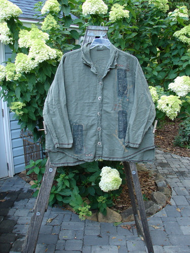 Barclay Hemp Cotton Metal Button Workshirt with Asian Script and Stand-Up Collar, displayed on a wooden stand, featuring exterior contrasting stitchery and shirttail hemline, from Bluefishfinder.com.