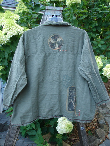 Barclay Hemp Cotton Metal Button Workshirt with Asian Script detail displayed on a stand, showcasing its exterior contrasting stitchery and full metal button front.