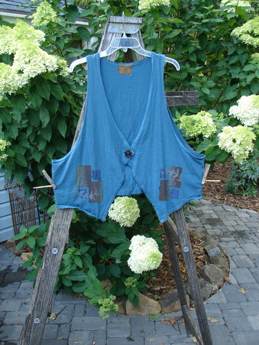 Barclay Calligrapher's Crop Vest Fern Window Blue Tealen Size 1 displayed on a wooden ladder, showcasing its deep V neckline, single button closure, dramatic front points, and cropped rear length.