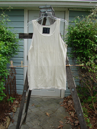 Barclay Lightweight Basic Tank Top Unpainted Pebble Smaller Size 2, displayed on a clothesline, showcasing its straight bodice and rounded neckline, emphasizing its suitability for effortless layering.