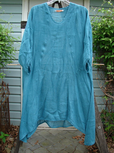 Barclay Linen High Vent Rear Tab Dress Unpainted Turquoise Size 1 hanging on a clothesline, showcasing its A-line shape, three-quarter sleeves, and tall side vents.