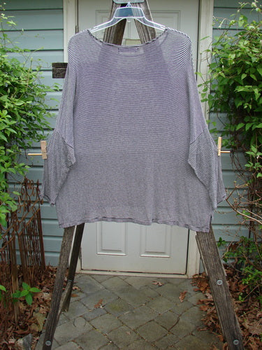 Barclay Organic Spandex Square Shirttail Top with black and white pinstripes, featuring a wide, boxy shape and dolman shoulders, displayed on a clothes rack.