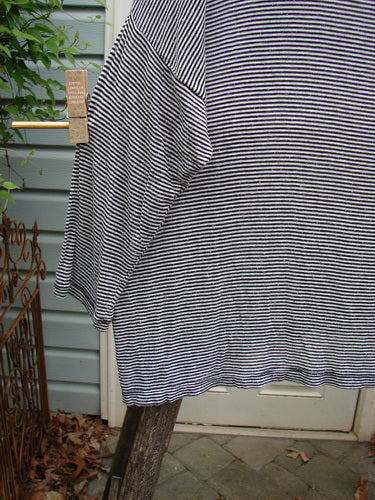 Barclay Organic Spandex Square Shirttail Top in Black White Pinstripe, featuring a boxy shape and dolman shoulders, hangs on a clothesline, showcasing its lightweight, flowing design.