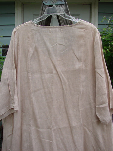 Barclay Linen Drop Pocket Bell Dress Unpainted Sand Size 1 displayed on a hanger, showcasing its unique A-line shape, three-quarter sleeves, and dual drop wrap side pockets, ideal for expressing individual style.