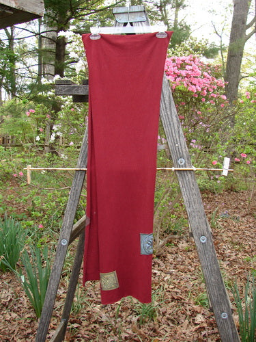 2000 PMU Patched Scarf Celtic Deep Burgundy One Size displayed draped on a wooden ladder, highlighting its generous length and thinner width with raw edges and classic Celtic theme patches.