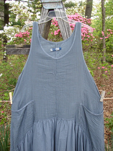 Barclay Gauze Dual Pocket Varano Jumper Unpainted Stripe Moss Size 0 displayed outdoors, showcasing its oval neckline, deep arm openings, and two deep pockets against a natural backdrop, highlighting its unique design and craftsmanship.