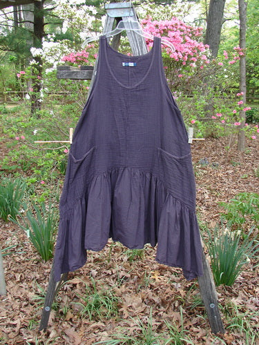 Barclay Gauze Dual Pocket Varano Jumper Unpainted Plum Size 0 displayed on a clothes rack, featuring a textured upper bodice, batiste flounce, deep pockets, and oval neckline.