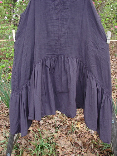 Barclay Gauze Dual Pocket Varano Jumper Unpainted Plum Size 0, hanging outdoors, features a textured gauze bodice, batiste flounce, deep pockets, and an oval neckline, epitomizing BlueFishFinder's vintage and expressive style.