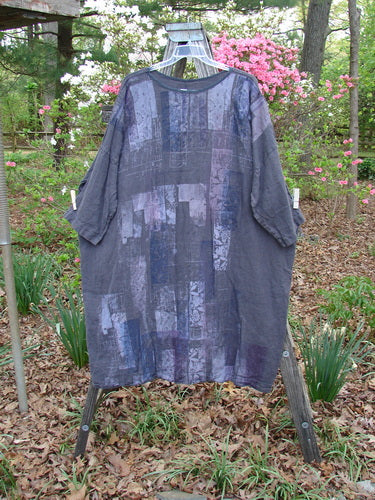 Barclay Linen Oversized Canyon Dress Floral Cityscape Black OSFA displayed on a clothes rack, featuring a rounded neckline, drop shoulders, and three-quarter sleeves, embodying BlueFishFinder's unique, expressive style.