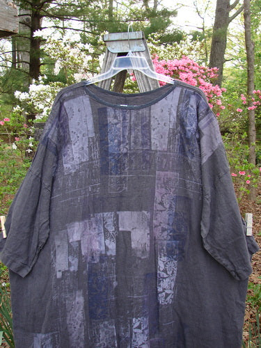 Barclay Linen Oversized Canyon Dress Floral Cityscape Black OSFA displayed on a mannequin, showcasing its round neckline, drop shoulders, three-quarter dolman sleeves, and pocketless design with a floral cityscape theme.