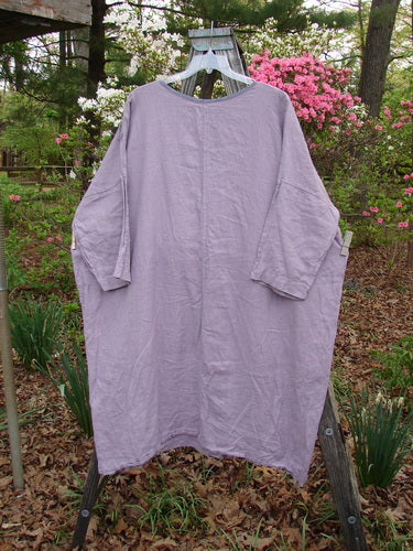 Barclay Linen Oversized Canyon Dress Floral Garden Lilac OSFA displayed on a swinging hanger, showcasing its rounded neckline, drop shoulders, and three-quarter dolman sleeves, embodying Bluefishfinder.com's vintage elegance.