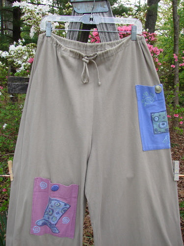 1997 Cubist Pant Top Hat Wheat Altered Size 1 hanging on a clothesline, showcasing oversized pockets with vintage buttons and a full drawstring waist, embodying Bluefishfinder's unique vintage style.