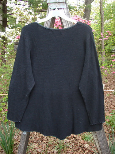 Barclay Thermal Bamboo V Bottom Top Berry Branch Black Size 2 displayed on a wooden clothes rack, showcasing its rounded neckline, long sleeves, and unique widening shape, embodying BlueFishFinder's vintage style.