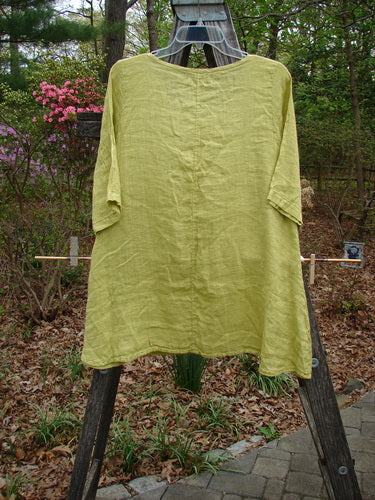 Barclay NWT Linen Springtime Top Unpainted Citron Size 0 displayed on a wooden stand, showcasing its rounded neckline, flowy A-line shape, and almost three-quarter sleeves, embodying Blue Fish Clothing's vintage, creative style.