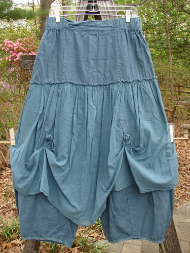 Barclay Linen Batiste Fusion Pant Skirt Unpainted Teal Size 0, featuring ruffles and dual tie accents, hangs on a line, showcasing its elegant, airy design.