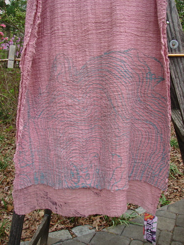 Barclay NWT Crinkle Cotton Scarf Wheat Field Plum Rose OSFA hangs on a line, showcasing its crinkled texture and wheat field design, embodying a cozy, versatile accessory from BlueFishFinder.com.