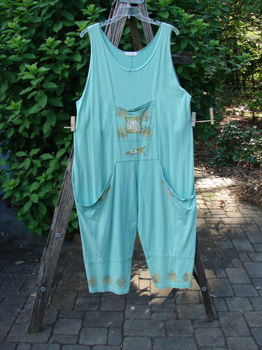 1997 Farmer Brown Overall Beach Salamander Altered OSFA hanging on a clothesline, showcasing its wide, swingy legs and whimsically painted dual front bushel pocket, reflecting vintage comfort and playful style.