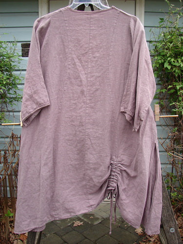 Barclay Linen High Vent Venetian Dress Celtic Fern Lavender Size 1 displayed on a hanger, showcasing curved seams, a softly dipped V neckline, and high side vents, highlighting its elegant drape and feminine shape.