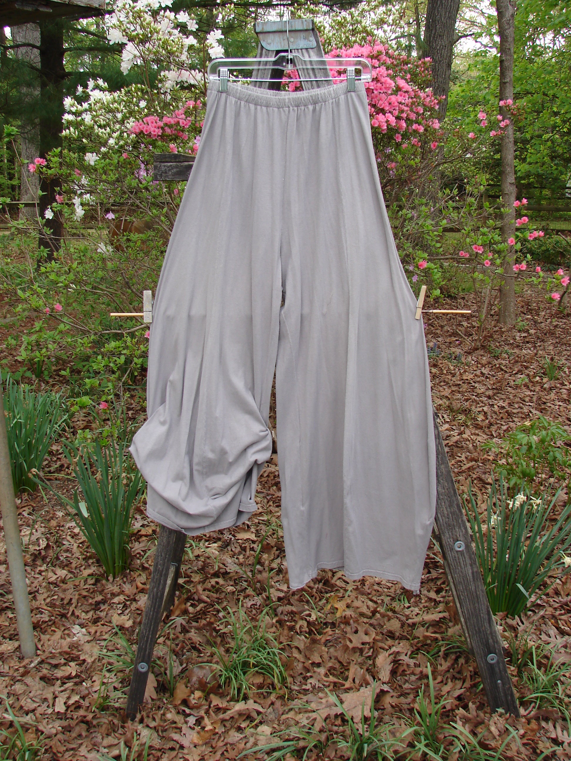 Barclay Lightweight Tie Bottom 4 Square Pant Unpainted Sand Size 0, hanging on a clothesline in a garden, showcasing its flowing design and organic cotton texture.