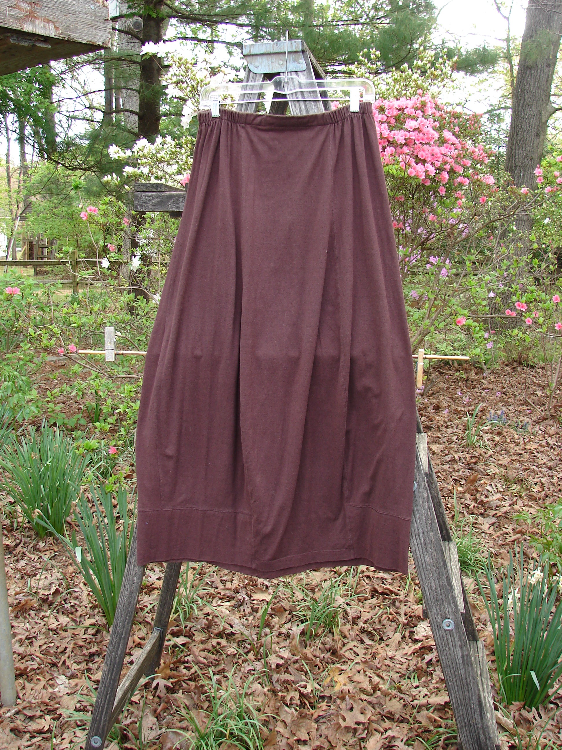1998 Wool Merino Pria Skirt Unpainted Raisin Size 1, displayed on a clothesline, showcasing its unique squarish lower shape with sectional panels and diagonal seams, highlighting its elegant drape and craftsmanship.