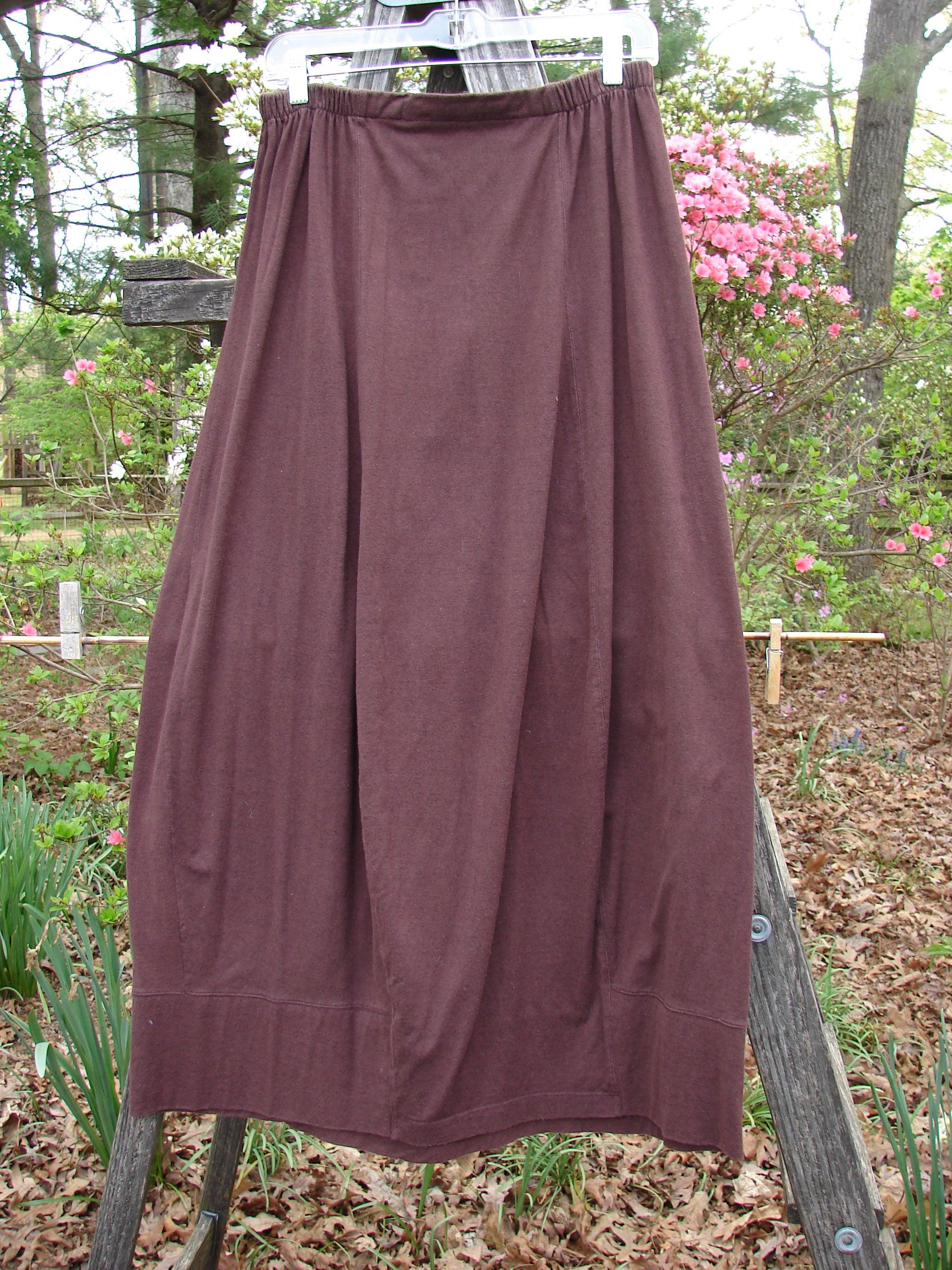 1998 Wool Merino Pria Skirt Unpainted Raisin Size 1 displayed on a wooden pole outdoors, highlighting its unique four squarish lower shape and sectional panel design, reflecting vintage Blue Fish Clothing style.