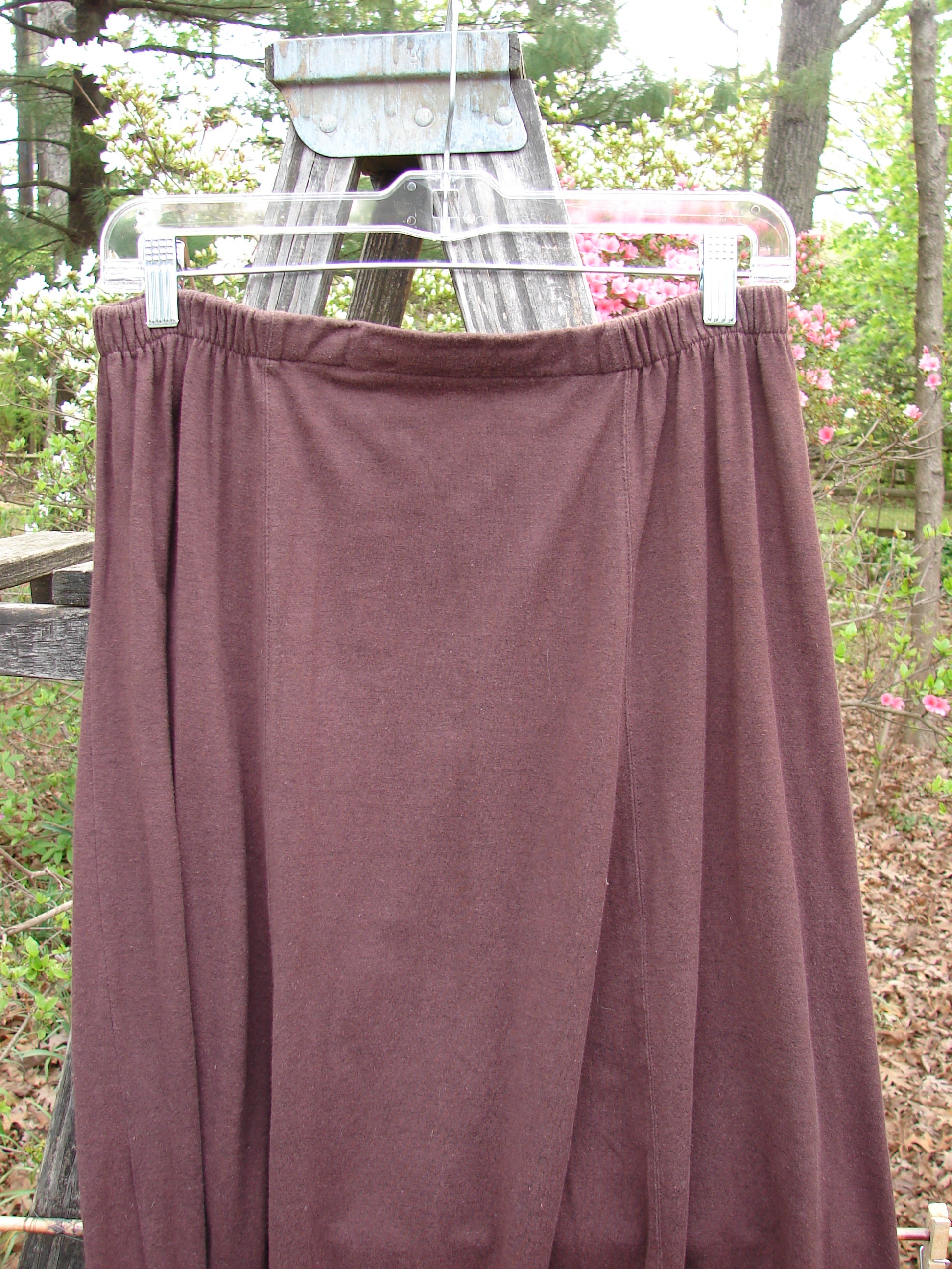 1998 Wool Merino Pria Skirt Unpainted Raisin Size 1 displayed on a clothesline outdoors, highlighting its unique squarish lower shape, sectional panels, and diagonal seams, embodying vintage Blue Fish Clothing style.