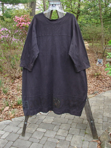 2000 Interlock Glassgow Coat Dress Celtic Black Size 2 displayed on a wooden pole, showcasing its full front line of oversized buttons, and a wide swingy hem with classic Celtic-themed paint.