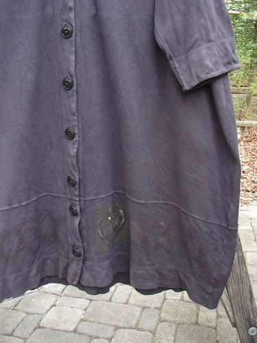 Close-up of the 2000 Interlock Glassgow Coat Dress Celtic Black Size 2, showcasing oversized buttons, V-shaped neckline, and distinctive Celtic-themed paint, emphasizing its vintage-inspired, generously flowing design.