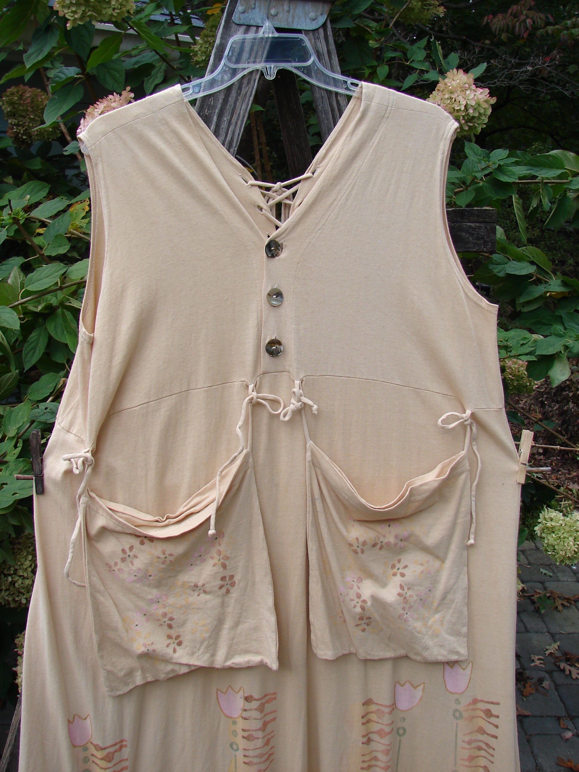 Barclay Salt Water Taffy Jumper Tulip Garden Wheat Size 2 displayed on a wooden hanger, featuring front pockets, shell-textured buttons, and a playful tulip garden design, highlighting its vintage-inspired style.