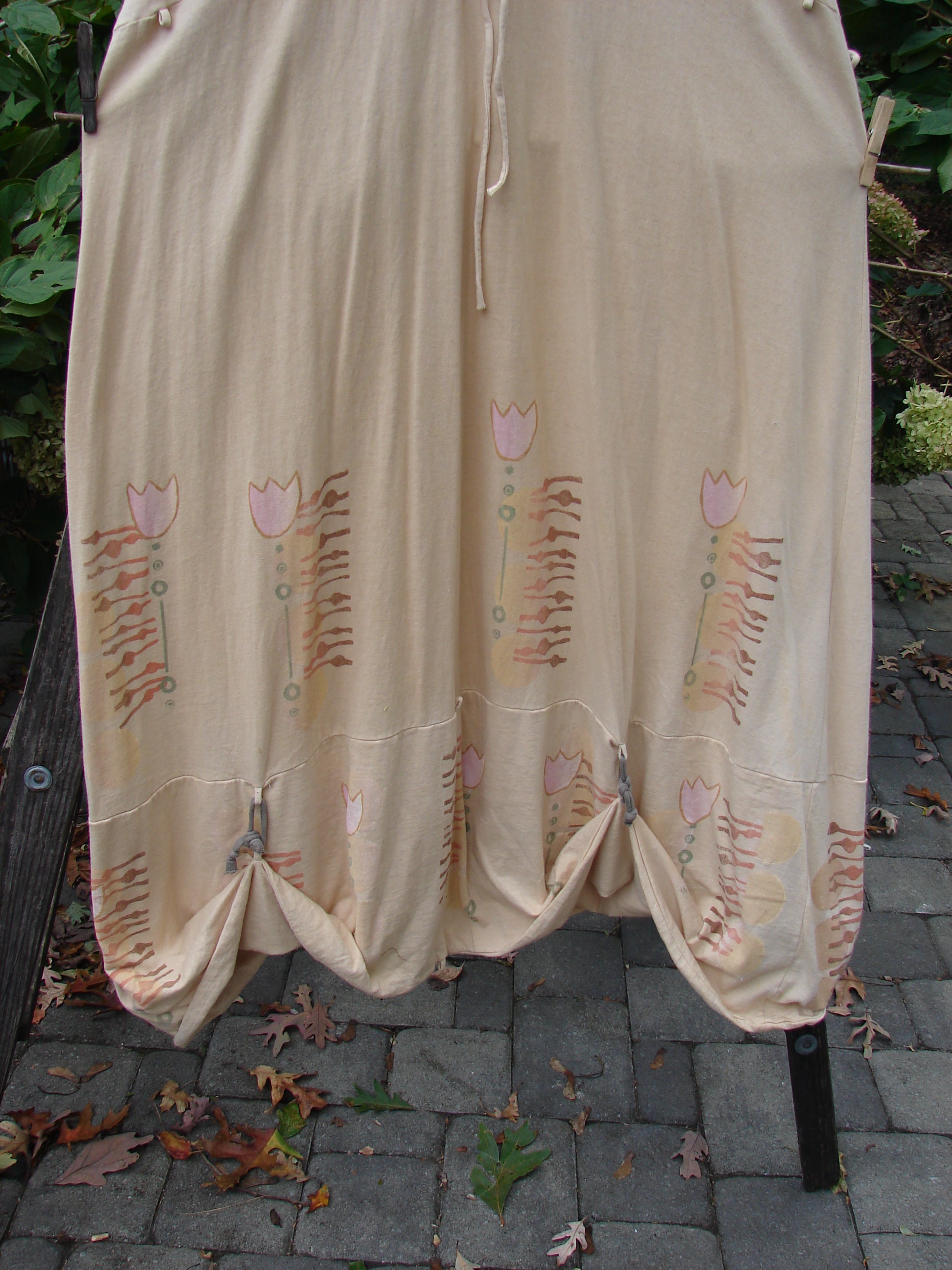 Barclay Salt Water Taffy Jumper Tulip Garden Wheat Size 2, featuring pink floral patterns, rippie accents, and shell-textured buttons, showcasing its unique design and organic cotton fabric. Perfect for expressing individuality.