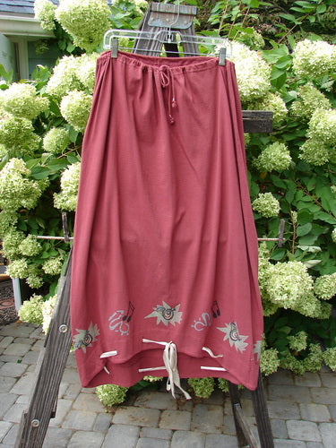 1992 Buttonloop Skirt Pomegranate Music OSFA: A long skirt with buttonholes and hand-dyed silk ribbon, featuring a drawcord waist and varying hemline, displayed on a rack.