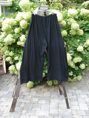 Barclay Drawcord Plane Wave Pant Unpainted True Black Size 2 displayed on a wooden stand, showcasing its full drawcord waistline and unique paneled design, emphasizing the brand's dedication to individuality.