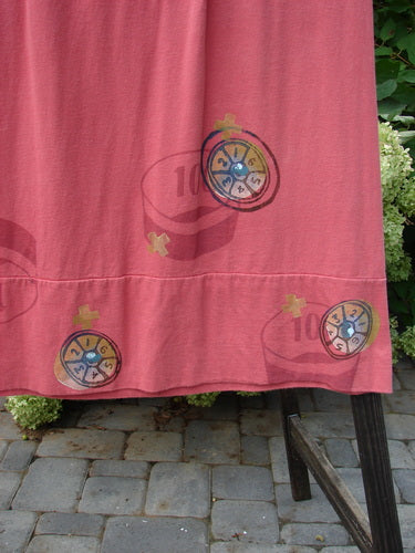 1998 Scrabble Skirt Games Cerise Size 2: Red dress with bingo cards, flat folded waist, rear elastic, horizontal panels, lower banded sweep, upper finger pockets, and a classical games theme.