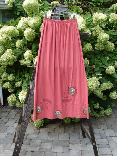 1998 Scrabble Skirt Games Cerise Size 2 displayed on a wooden rack, highlighting its flat folded front, rear elastic waistband, and horizontal panel design.