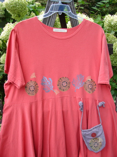 1997 Ocean Pearl Dress Star Coral Firefly Size 2 displayed on a wooden rack, featuring a slight empire waist, rounded neckline, and a tiny painted pocket tied with coordinating rippies.