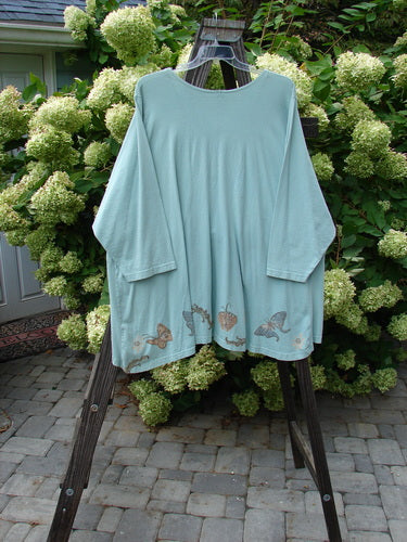 1994 Treasure Jacket Garden Friend Sea Water OSFA displayed on a rack, featuring butterfly motifs, nine-button front, drop shoulder seams, and front floppy pockets with button closure.