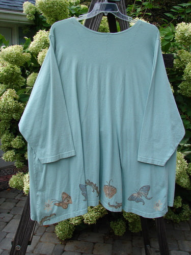 1994 Treasure Jacket Garden Friend Sea Water OSFA featuring butterfly designs, long sleeves, front floppy pockets, nine-button front, drop shoulder seams, and a varying hemline, made from mid-weight cotton, in excellent vintage condition.