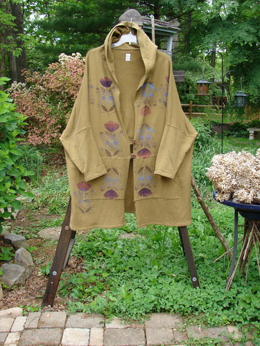 Barclay Fleece Two Button Hooded Jacket Sun Man Yellow Olive Size 3 displayed on a rack, featuring a generous hood, two wooden buttons, vertical floral design, and full-length rear Sun Man painting.