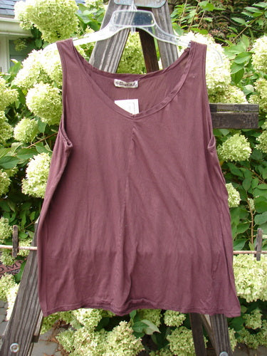 Barclay NWT Batiste Decora Tiny Tank Unpainted Bordeaux Size 2 displayed on a wooden fence, showcasing its vertical neckline tie, slight A-line shape, and diagonal insert.