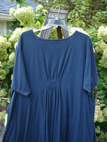 Barclay Farmer Jen Tunic Dress Shell Flower Navy Size 2 displayed on a hanger, featuring a deep rounded neckline, oversized front drop pockets, and a bell-shaped lower hem, all crafted from organic cotton.