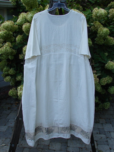 Barclay Linen Cotton Sleeve Banded Hem Pleat Dress Curl Fern White Size 2 displayed on a swinger, showcasing three-quarter sleeves, vertical pleats, and a rounded neckline.