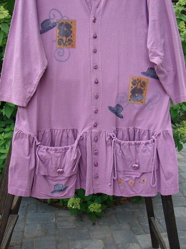1997 Belladonna Jacket Tall Hat Geranium Size 1: A purple dress with pockets, a hat, and flowers. Flirty flounce and knotted buttons. Versatile and fun swingy piece.